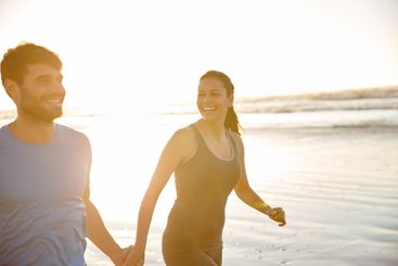 Love, holding hands and walking with couple at beach for...