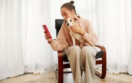 Woman sitting comfortably with disabled dog while...