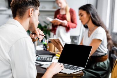 selective focus of student looking at laptop with blank...