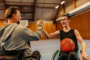 Cheerful male and female athletes with disabilities doing...