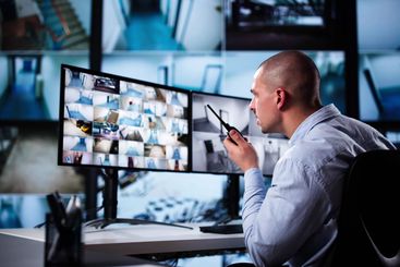 Security System Cctv Monitor Room. Man Using Walkie Talkie