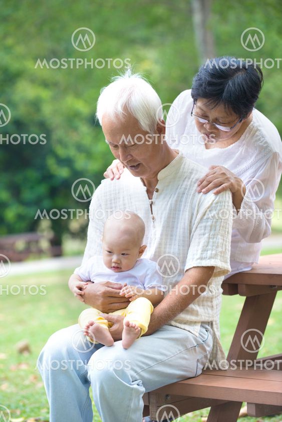 asian grandparents playing with baby grandson at outdoor