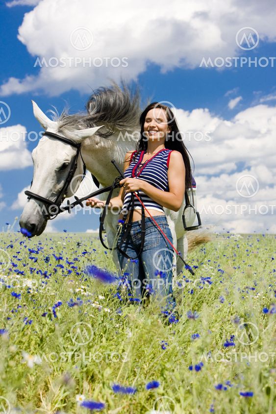 equestrian with a horse on meadow