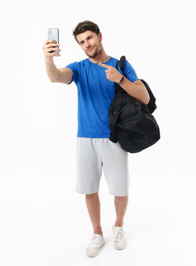 Full length photo of caucasian sportsman with big bag...