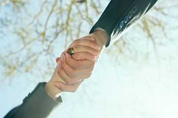 Handshake, outdoor and business people with low angle,...