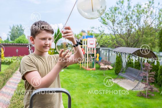 A boy in the backyard is plugging in bulbs. Cleanup in...