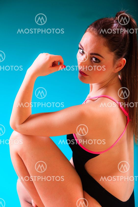 Sporty fit woman at swimming pool edge poolside.