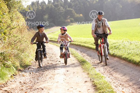 Young father with children ride bikes in park