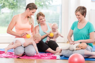 Young women practicing massage for their babies in...