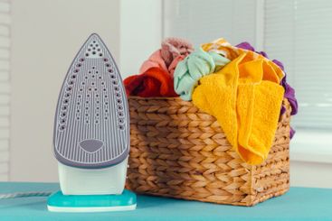 Iron on ironing board on light home interior background