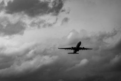 Commercial airplane on grey sky and clouds with copy...