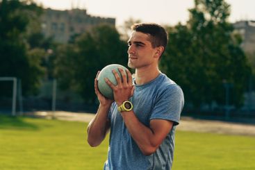 Young athlete prepares to throw a ball on a sunny day at...