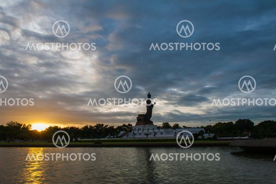 Walking Buddha statue at Buddhamonthon (Phutthamonthon), Buddhist Park in Nakhon Pathom, Thailand, in twilight moment