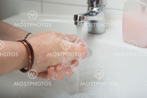 hands of woman whashing hands to protect against the...