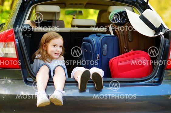 Two adorable little sisters sitting in a car