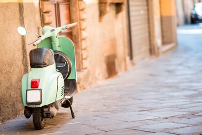 Light blue scooter on the street of the old city. Old...