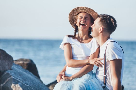 Happy young romantic couple relaxing on the beach and...