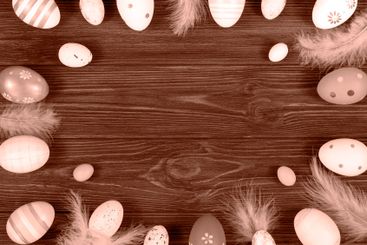 Easter frame with eggs and feathers on a wooden...