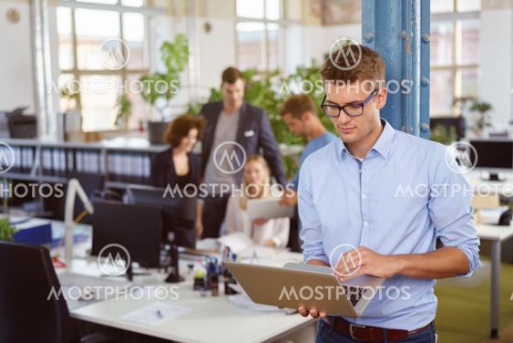Young businessman working on a handheld laptop