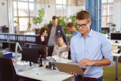 Young businessman working on a handheld laptop