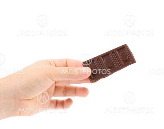 Hand holds tasty morsel of dark chocolate.