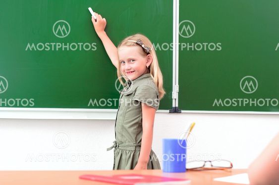 Schoolgirl writing on a blackboard