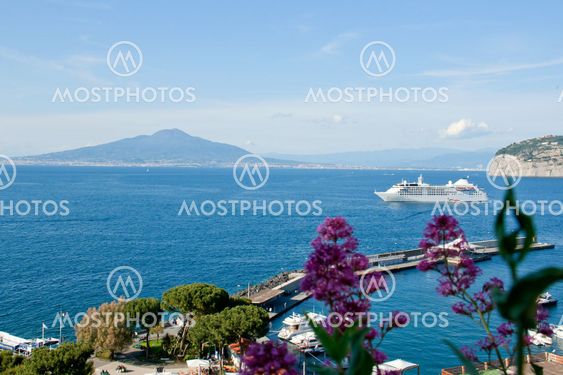 White cruise ship in Sorrento with Vesuvius volcano on the background