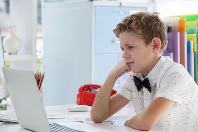 Concentrated businessman working on laptop while sitting...