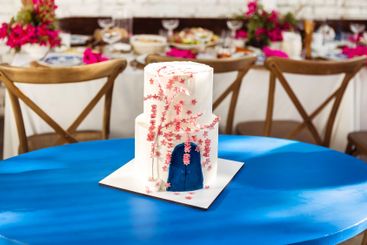 A cute white two-tiered delicious cake on a blue table....