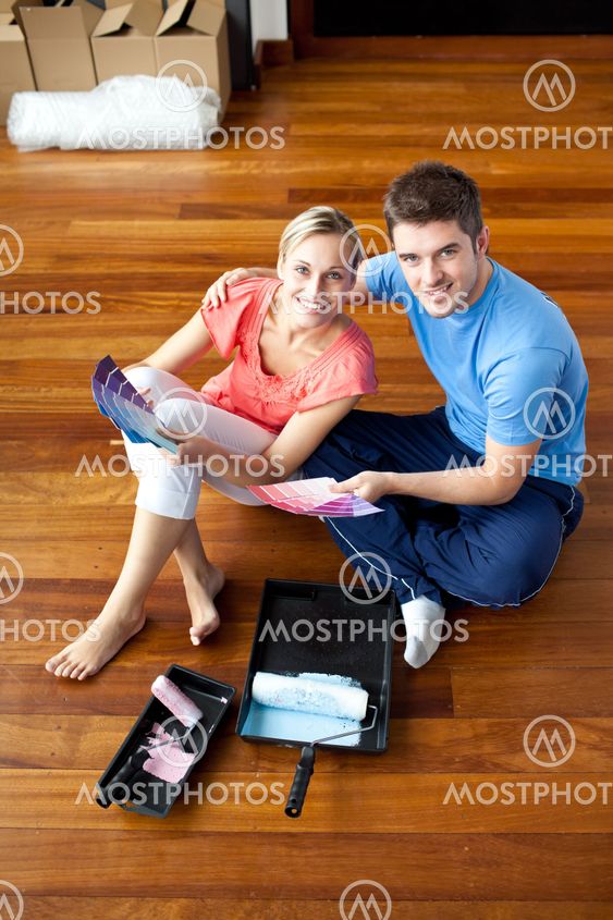 Beautiful couple sits on the floor picking colors