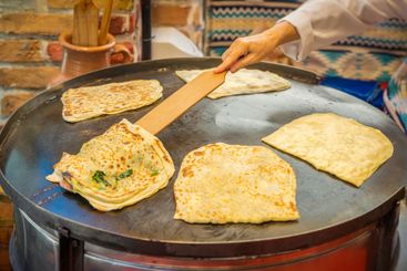 Woman in white uniform preparing traditional Turkish...