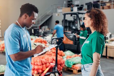 People, volunteer and writing on clipboard at warehouse...