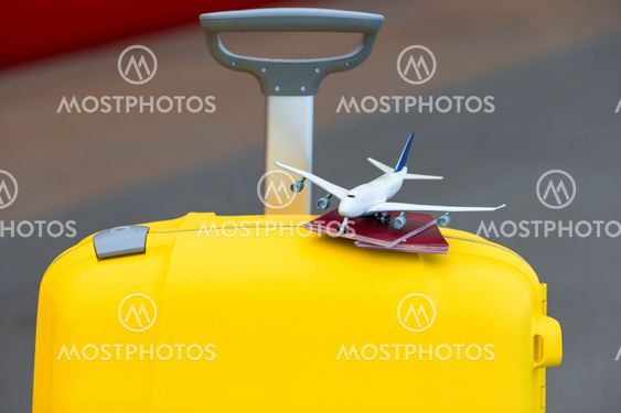 Closeup red passports and airplane small model on yellow...