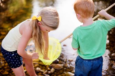 Outdoor, river and children with net for fishing,...