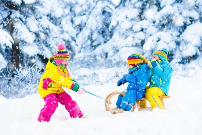 Kids on sleigh ride. Children sledding. Winter snow fun.