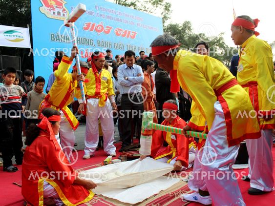People in traditional costume exam to make round sticky...