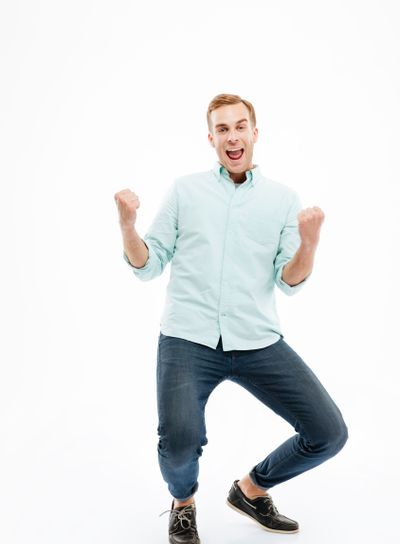 Full length of cheerful young man celebrating success