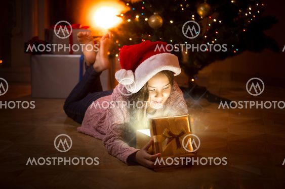 happy girl lying on floor and looking inside of magic...