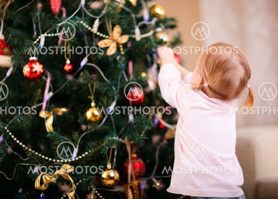 Little girl decorating Christmas tree