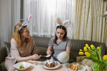 Mother and daughter decorating Easter cakes together.