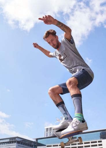 Man, jump and air with skateboard for parkour stunt,...