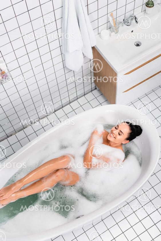 Top view of cheerful woman with closed eyes enjoying in...