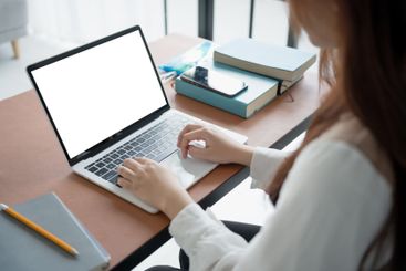 Woman using laptop with white screen on deck