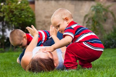 Young woman playing with children outdoors