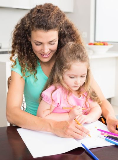 Mother and daughter colouring together at the table
