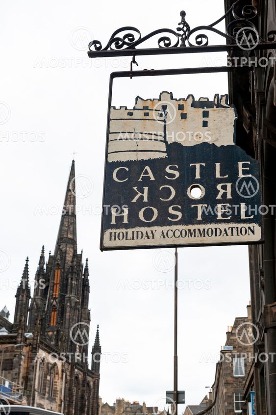 Edinburgh, Scotland - April 2018: Name sign in front of Castle Rock Hostel on Royal Mile in Scotland with Tron Kirk, former gothic church, now functioned as The Hub, a venue for various events and festivals