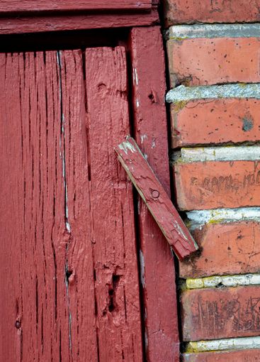 Closeup, red door and old plank lock with rusty metal...