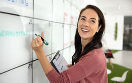 Happy successful manager woman filling out cells of table