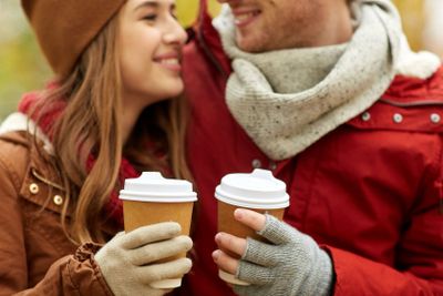 close up of happy couple with coffee in autumn