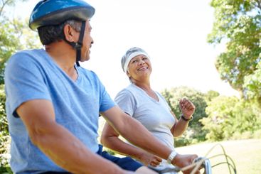 Bike, exercise and senior couple in park together for...